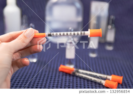 Woman holds insulin syringe medical blue background 132956854
