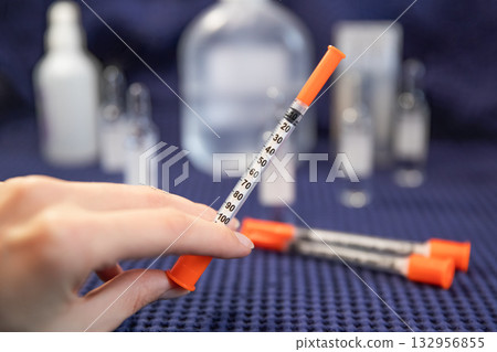 Woman holds insulin syringe medical background blurred Woman holds insulin syringe medical background blurred 132956855