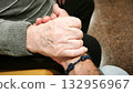 A man and an elderly man hold hands. The scene is warm, comforting, and reflects love and understanding. 132956967