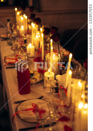 Warm candlelit banquet table with roses and crystal decor in restaurant Warm candlelit banquet table with roses and crystal decor in restaurant 132957053