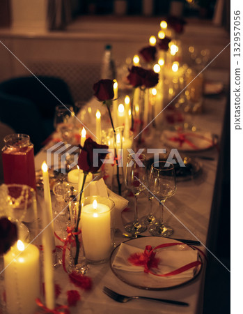 Warm candlelit banquet table with roses and crystal decor in restaurant Warm candlelit banquet table with roses and crystal decor in restaurant 132957056