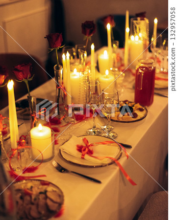 Warm candlelit banquet table with roses and crystal decor in restaurant Warm candlelit banquet table with roses and crystal decor in restaurant 132957058