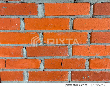 Close-up of a wall made of red brick laid with cement mortar. Close-up of a wall made of red brick laid with cement mortar. 132957520
