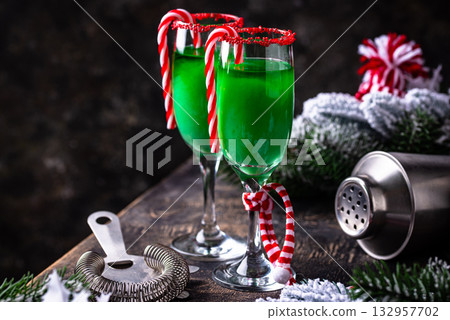 Christmas green cocktail punch with candy cane Christmas green cocktail punch with candy cane 132957702