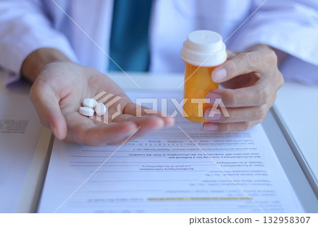 Pharmacist, Doctor or General practitioner explain to patient how to use prescribed medicine correctly by explain dosage, frequency, and timing. Pharmacist, Doctor or General practitioner explain to patient how to use prescribed medicine correctly by explain dosage, frequency, and timing. 132958307