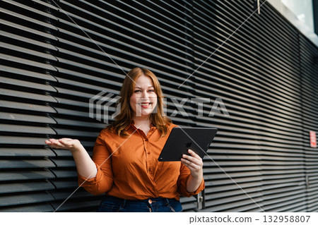 Curvy adult woman holding tablet, reading something. Curvy adult woman holding tablet, reading something. 132958807