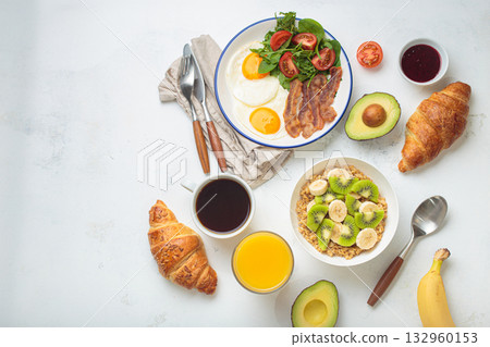 Breakfast white table fried eggs vegetables salad, oats fruit, croissants, coffee, juice healthy copy space. 132960153
