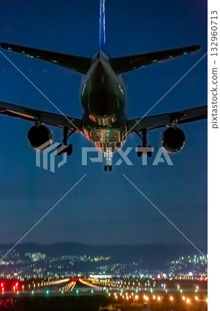 Plane landing at the airport at night_Vertical 132960713
