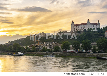 Scenic view of Bratislava Castle at sunset, overlooking the Danube River. Captures the iconic castle in Slovakia with a dramatic sky, blending historical architecture with natural beauty. Scenic view of Bratislava Castle at sunset, overlooking the Danube River. Captures the iconic castle in Slovakia with a dramatic sky, blending historical architecture with natural beauty. 132961151