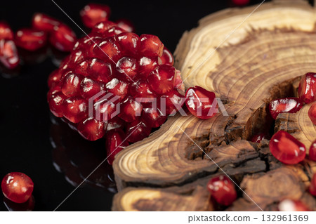 red ripe peeled pomegranate with large juicy grains, sweet pomegranate fruit with juicy red grains on the table, fruit close up red ripe peeled pomegranate with large juicy grains, sweet pomegranate fruit with juicy red grains on the table, fruit close up 132961369