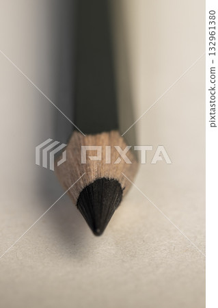 a black wooden pencil folded on cheap loose paper, one wooden pencil with graphite lead for drawing or other work 132961380