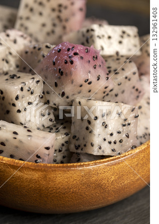 diced ripe red pitaya with lots of small black seeds and white soft sweet flesh inside, sweet ripe dragon fruit with black small seeds and light flesh cut in half into small cubes diced ripe red pitaya with lots of small black seeds and white soft sweet flesh inside, sweet ripe dragon fruit with black small seeds and light flesh cut in half into small cubes 132961408