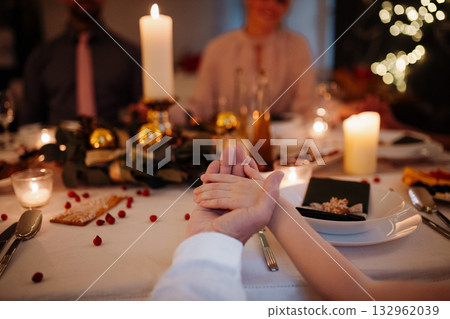Family holding hands in prayer during Christmas dinner. 132962039