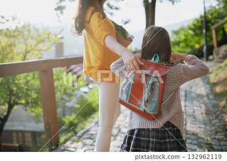 Parent walking child to school on first day, holding hands. Parent walking child to school on first day, holding hands. 132962119