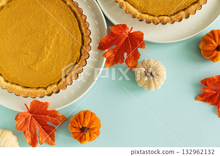 Festive Pumpkin Pie with Autumn Leaves, Decorative Pumpkins, and Gold Cutlery 132962132