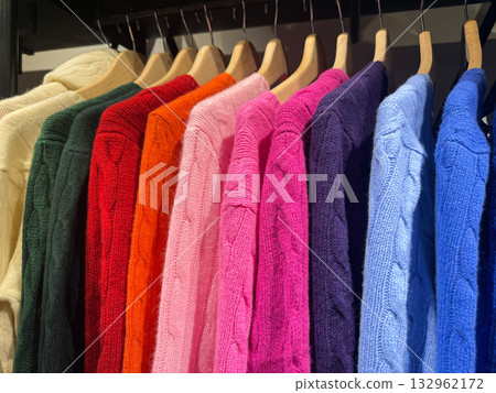 Cozy winter sweaters displayed on clothing rack 132962172