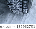 Winter car tire tread with snow between blocks close up view Winter car tire tread with snow between blocks close up view 132962751