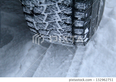 Winter car tire tread with snow between blocks close up view Winter car tire tread with snow between blocks close up view 132962751