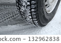 Asymmetrical winter tire with snow in tread blocks close up Asymmetrical winter tire with snow in tread blocks close up 132962838