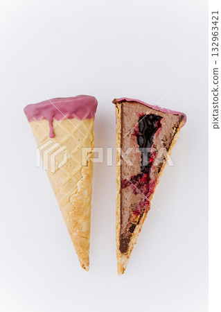 Whole and sliced berry chocolate ice cream cone on white background, minimalist food concept Whole and sliced berry chocolate ice cream cone on white background, minimalist food concept 132963421