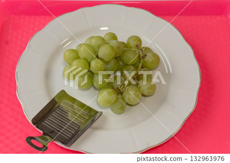 Green grapes on white plate 132963976