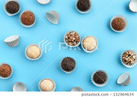Typical Brazilian sweet brigadeiro. Assorted flavors of candies in a line on a blue background 132964634