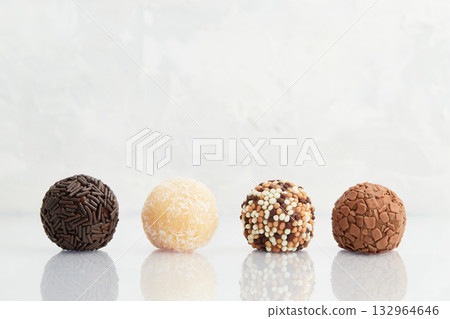Typical Brazilian sweet brigadeiro. Line of candies with different tastes on a marble background Typical Brazilian sweet brigadeiro. Line of candies with different tastes on a marble background 132964646