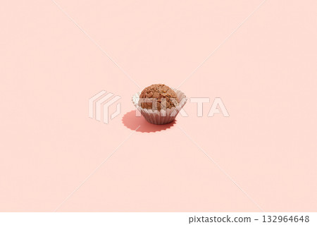Typical Brazilian sweet brigadeiro. One cocoa candy on a pink background Typical Brazilian sweet brigadeiro. One cocoa candy on a pink background 132964648