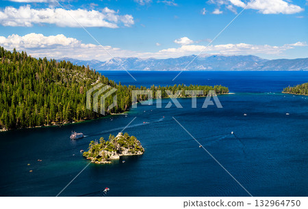 High-angle view of iconic Emerald Bay and Fannette Island in Lake Tahoe. Boats, including a tour ship, cruise on the deep blue water under a cloudy sky. Represents summer vacation and nature landmarks High-angle view of iconic Emerald Bay and Fannette Island in Lake Tahoe. Boats, including a tour ship, cruise on the deep blue water under a cloudy sky. Represents summer vacation and nature landmarks 132964750