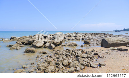 Large Coastal Boulders and Scattered Rocks on a Sandy Tidal Beach with Calm Tropical Ocean Water Large Coastal Boulders and Scattered Rocks on a Sandy Tidal Beach with Calm Tropical Ocean Water 132965357