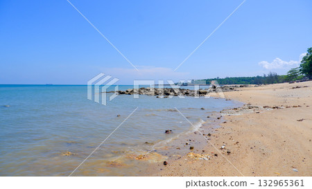 Expansive Tropical Sandy Beach and Calm Ocean with Distant Rocky Breakwater and Green Headland Expansive Tropical Sandy Beach and Calm Ocean with Distant Rocky Breakwater and Green Headland 132965361