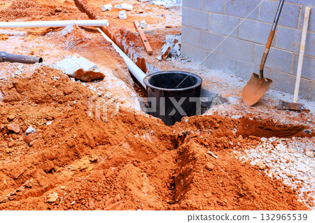 Workers are preparing at trench for drainage system installation in residential construction site. Workers are preparing at trench for drainage system installation in residential construction site. 132965539