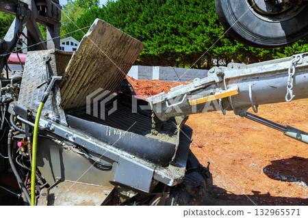 Construction machinery mixes concrete, preparing it for building foundation on works day. Construction machinery mixes concrete, preparing it for building foundation on works day. 132965571