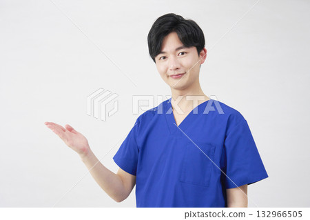 Doctor, nurse, dentist, caregiver, man pointing to the left with palm, white background Doctor, nurse, dentist, caregiver, man pointing to the left with palm, white background 132966505