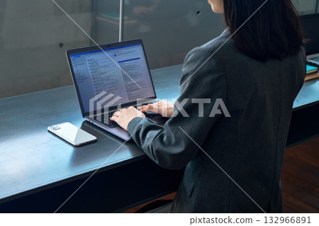 一位女商人正在辦公室操作電腦。 一位女商人正在辦公室操作電腦。 132966891