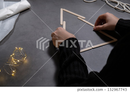 Christmas tree made of ice cream sticks. Gift idea. Do it yourself instruction eco-friendly decoration. Zero waste Making handmade presents children's diy projects. Holiday family time 132967743
