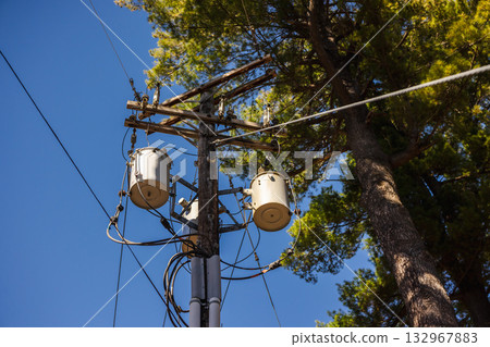 Utility pole with power transformers and cables against clear blue sky in the United States 132967883