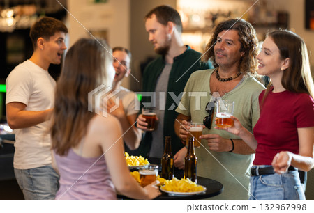Group of fans in bar talking and drinking beer 132967998
