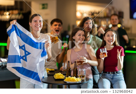 Group of friends cheer together for their favorite Israeli team in beer bar Group of friends cheer together for their favorite Israeli team in beer bar 132968042