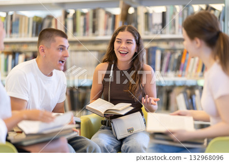 Students reading books while sitting in chairs 132968096