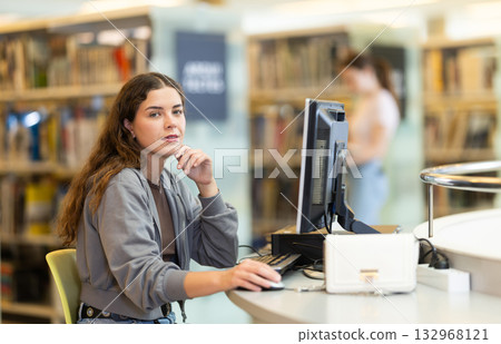 Female student working on computer in library Female student working on computer in library 132968121
