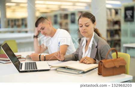 female student and a guy are preparing for lectures female student and a guy are preparing for lectures 132968203