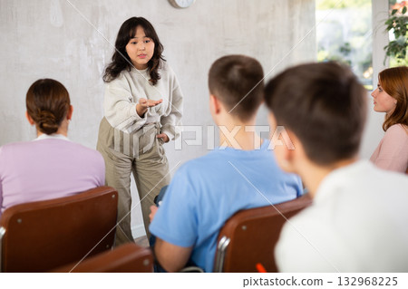 Asian girl student presenting report to fellow students 132968225