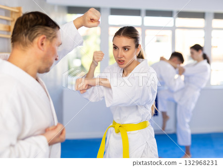 Adult man and young woman training karate techniques Adult man and young woman training karate techniques 132968231
