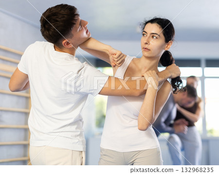 Young woman and guy training self-defense techniques 132968235