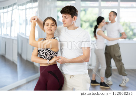 Girl paired up with young man, they train to perform disco fox dance, rehearse performance. Girl paired up with young man, they train to perform disco fox dance, rehearse performance. 132968285