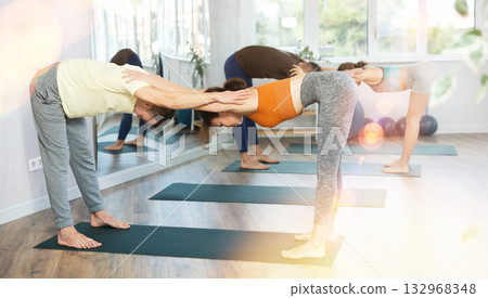 Young girl and man practicing pair yoga training holding each other hands. Concept of partner yoga Young girl and man practicing pair yoga training holding each other hands. Concept of partner yoga 132968348