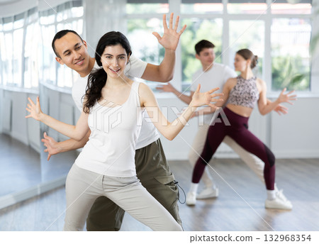 Happy young woman and man enjoying active boogie-woogie dance in studio Happy young woman and man enjoying active boogie-woogie dance in studio 132968354