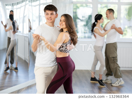 People learning tango dance at lessons in dance studio People learning tango dance at lessons in dance studio 132968364