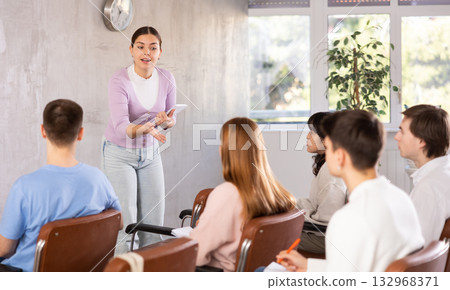 While working in classroom, female teacher answers questions that students had while studying new lesson While working in classroom, female teacher answers questions that students had while studying new lesson 132968371
